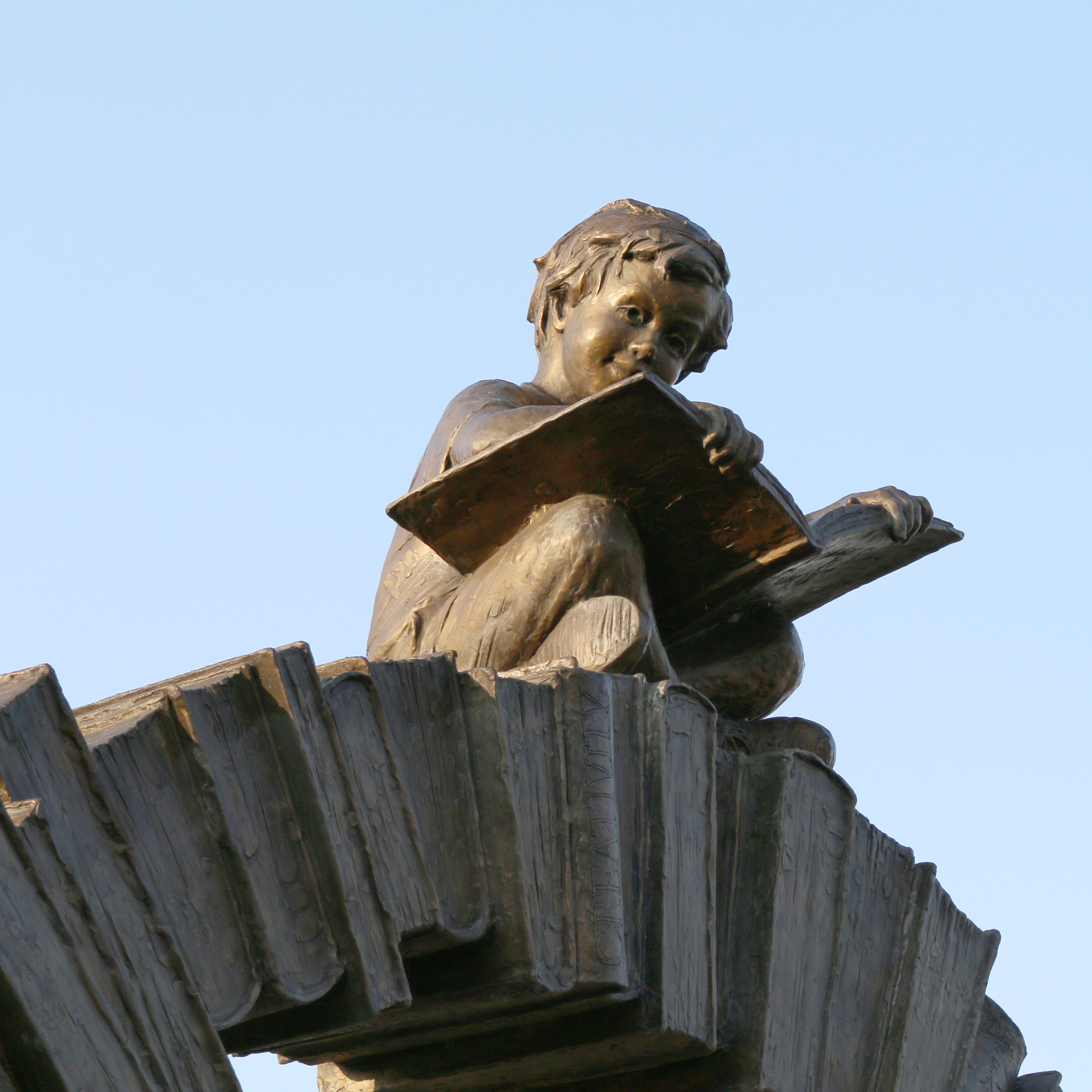 Boy reading on arch statue